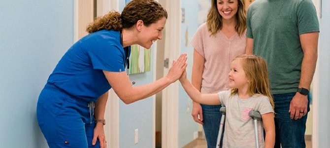 Long_Niña en muletas con tutores y médico